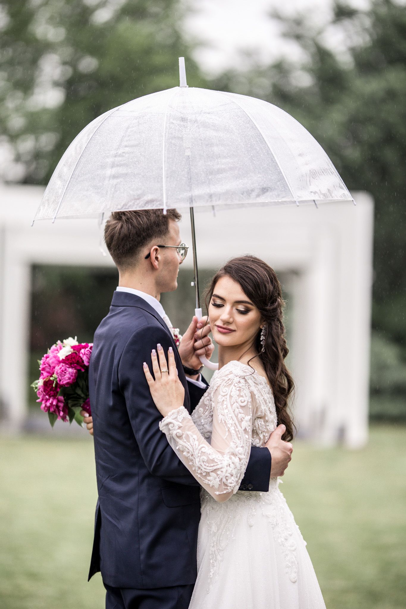 Sesja ślubna w deszczu pod przezroczystym parasolem